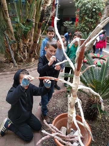 The children paint the tree they designed and created