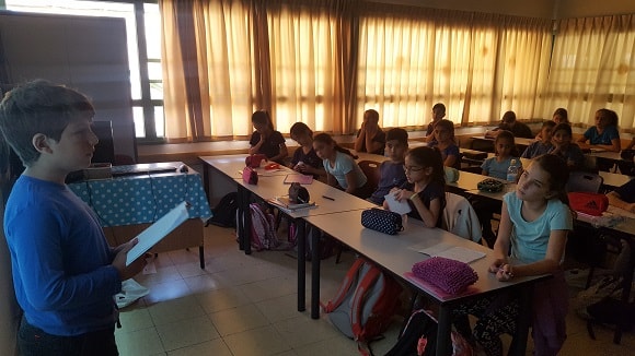 A child presents his idea of the project to his classmates